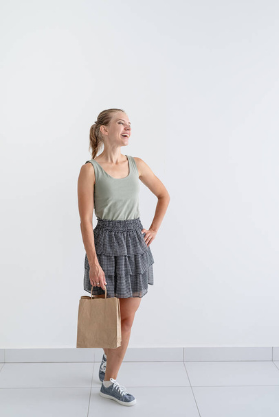 Online-Einkaufskonzept. Junge lächelnde Frau mit umweltfreundlichen Einkaufstaschen und Kreditkarte - Foto, Bild