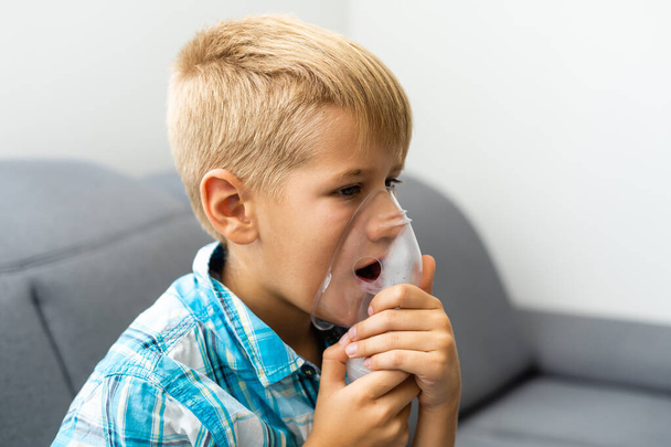 Mały chłopiec wdychający nebulizator w domu. - Zdjęcie, obraz