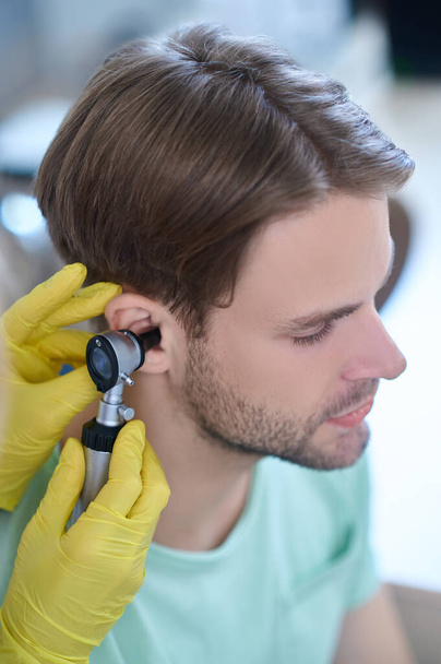 Young patients ear being examined with an auriscope - Foto, imagen