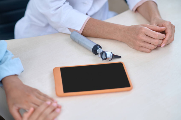Hands of doctor and patient sitting at table - Photo, Image