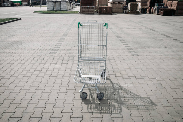Рынок корзин. Пустая тележка для покупок на парковке супермаркета. Время покупок товаров для дома, закусок или строительных материалов - Фото, изображение