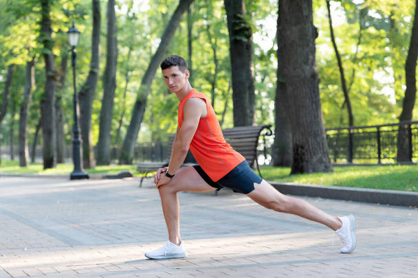 Warming up before workout. Fit guy hold lunge position. Man do warm-up exercises. Warm-up activities - Photo, Image
