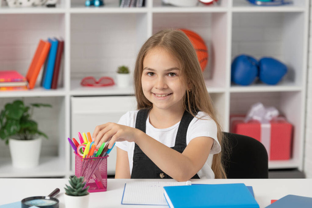 happy child taking stationery at school lesson in classroom wear uniform, study - Photo, Image