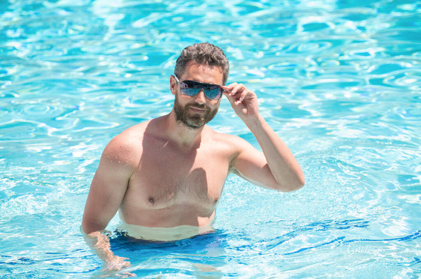 boldog szakállas férfi szemüvegben úszás medencében nyáron, pihenni - Fotó, kép