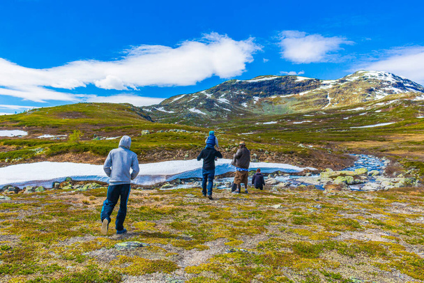 Viken Norway 09. June 2016 People hikers are trekking by the river at landscape of Vavatn lake and mountains in Hemsedal Norway. - Fotoğraf, Görsel