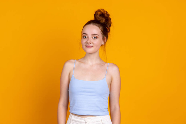Sweet young pretty girl isolated on yellow studio background. Female fashion model in casual clothes. Concept of human emotions, facial expression, natural beauty, youth - Φωτογραφία, εικόνα
