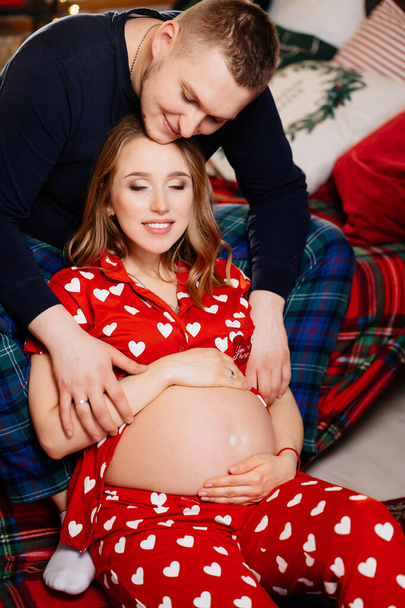 man and woman in love. family in pajamas in the New Years bedroom. pregnancy - Фото, зображення