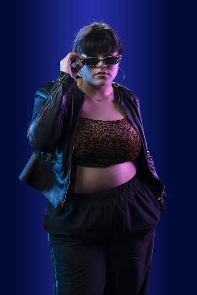 Portrait of a latin woman with pants and red cap, in a studio with blue background - Foto, Imagem