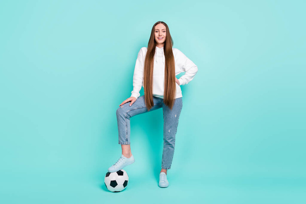 Parlak turkuaz rengi arka planda izole edilmiş, futbol oynayan neşeli kızın vücut ölçüleri tam boy. - Fotoğraf, Görsel