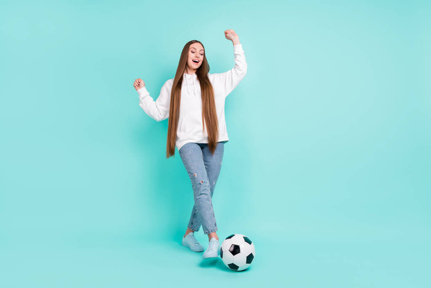 Photo of lucky shiny young woman dressed white hoodie smiling winning football match rising fists isolated teal color background - Φωτογραφία, εικόνα