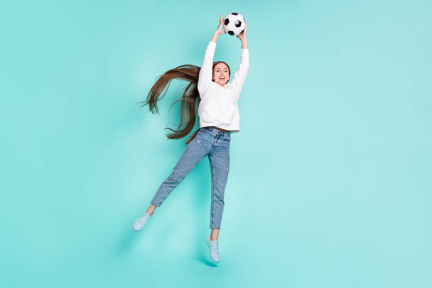 Full length body size view of pretty cheerful girl jumping catching ball isolated over bright teal turquoise color background - Photo, image