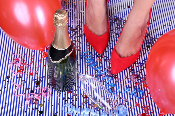 Legs with confetti, champagne and balloons on the floor - Fotoğraf, Görsel