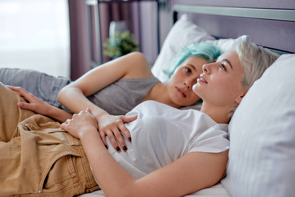 Young beautiful caucasian women lesbian couple lover lying on bed in the morning - Foto, Bild