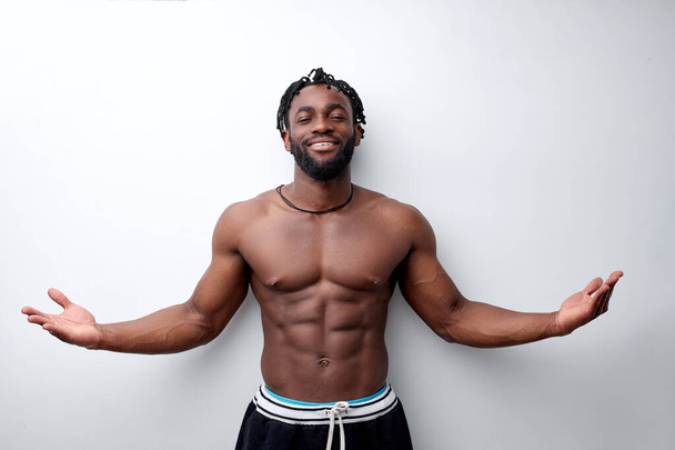Fit young man with beautiful torso, isolated on white background, spreading arms - Fotó, kép