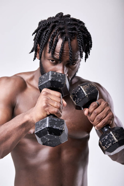 slim well-built athlete preparing for training, close up portrait, holding dumbbells - Photo, Image