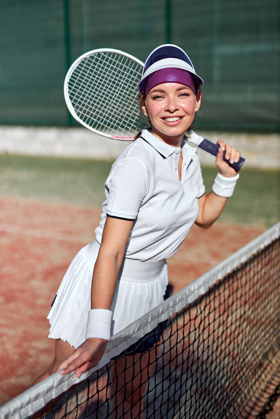 Are you ready to play. Positive sexy beautiful woman in sports clothing holding tennis racket - Zdjęcie, obraz