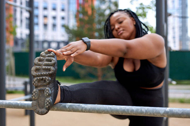 black american fat woman stretching legs, warming up legs before yoga or sport workout - Foto, Imagem