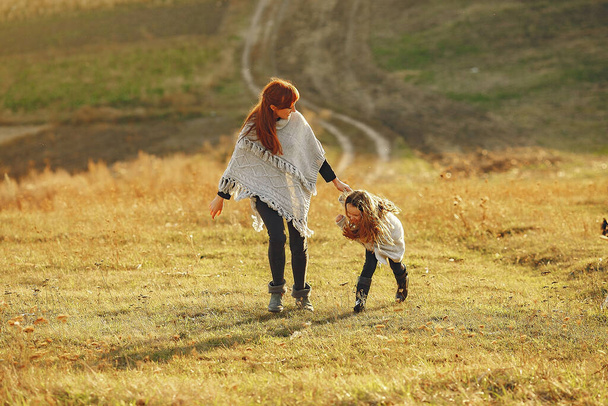 Mother with little daughter playing in a autumn field - Valokuva, kuva