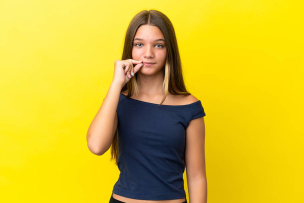 Little caucasian girl isolated on yellow background showing a sign of silence gesture - Fotoğraf, Görsel