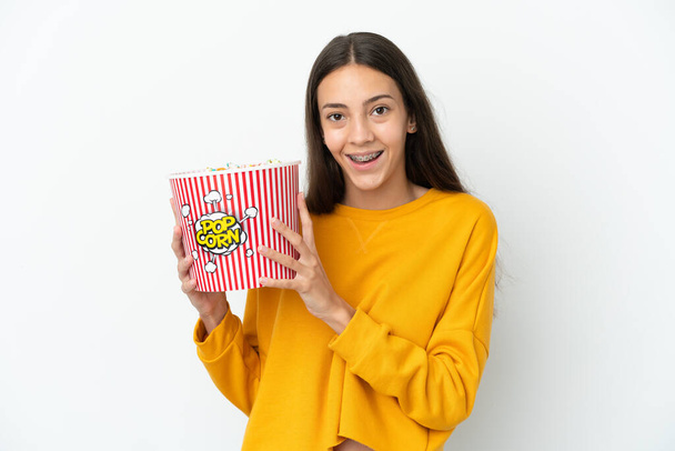 Jeune Française isolée sur fond blanc tenant un gros seau de popcorns - Photo, image