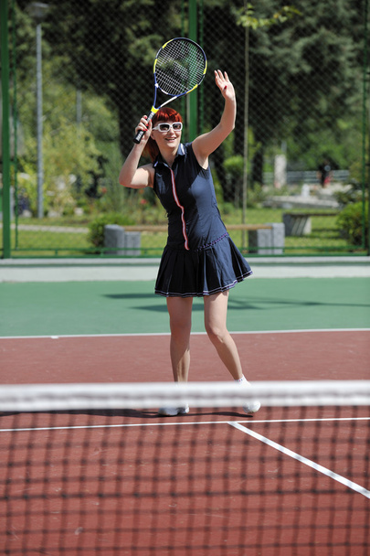 Young fit woman play tennis outdoor on orange tennis field at early morning - Foto, Bild