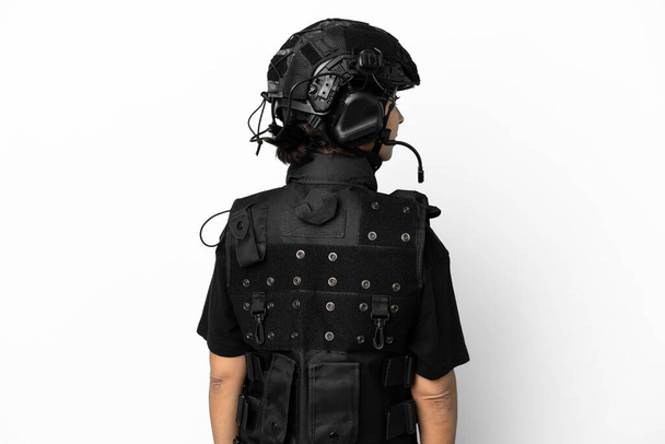 Mujer SWAT aislada sobre fondo blanco en posición trasera y mirando hacia el lado - Foto, Imagen
