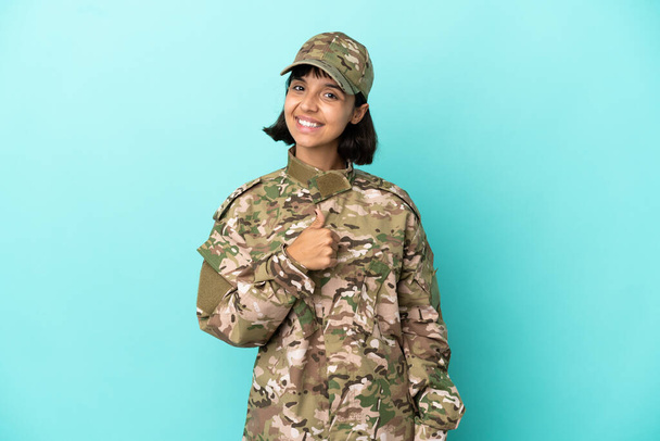 Militar mixta mujer aislada sobre fondo azul dando un gesto pulgar hacia arriba - Foto, Imagen