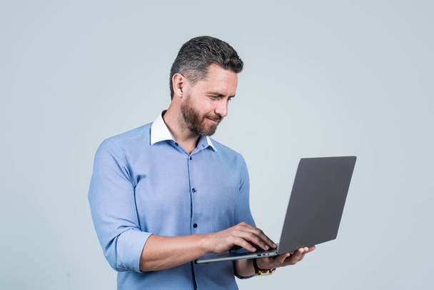 handsome smiling bearded businessman in shirt with laptop, pnline business - Fotó, kép