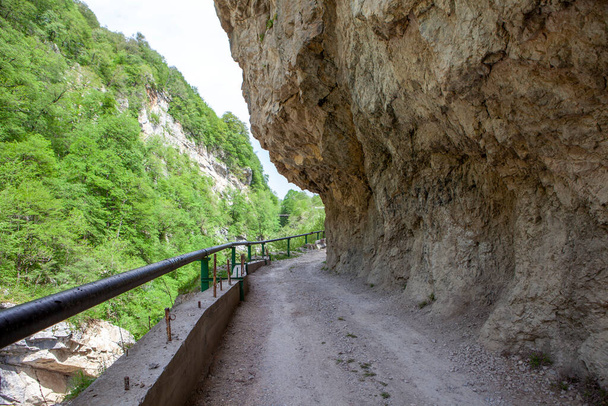 Dağda yapılmış bir tünel ve dağın etrafında eski bir yol. Digorskoe Boğazı. Kuzey Osetya. - Rusya. 17 Mayıs 2021 - Fotoğraf, Görsel