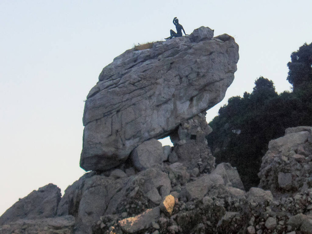 Steinfelsen mit einer Frauenskulptur auf einem Stein. Capri, Italien. - Foto, Bild