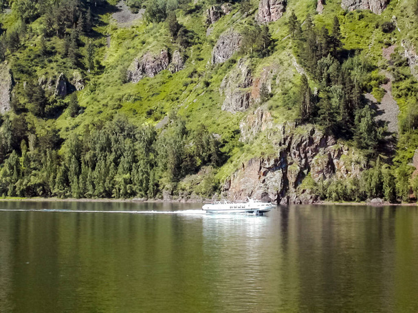 bateau flottant sur la rivière le long des montagnes et des forêts. Bateau à passagers. - Photo, image