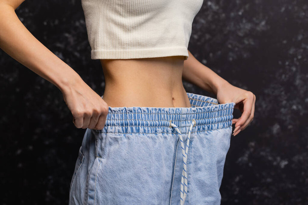 Woman showing how much weight she lost. - Φωτογραφία, εικόνα