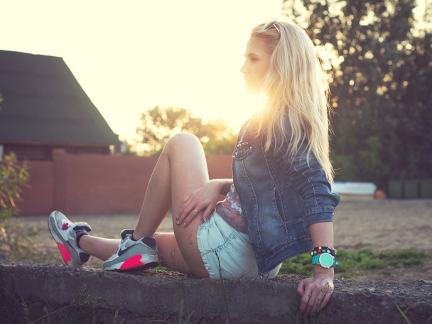 sonniges Porträt einer schönen Mode junge Mädchen Sommerabend im Freien. Weiches Licht. Sonnenschein. getönte warme Farben. - Foto, Bild