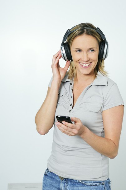 Jovens mulheres loiras ouvindo música com fones de ouvido tecnológicos
 - Foto, Imagem