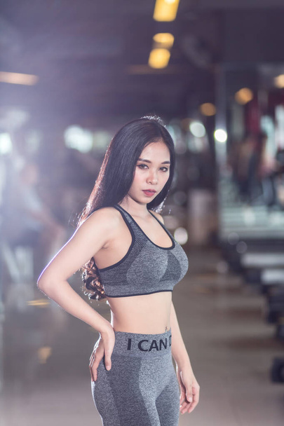 Fitness Asian women sitting in sport gym interior and fitness health club with sports exercise equipment Gym background. - Foto, imagen