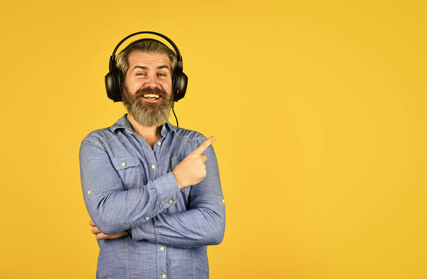 Hipster enjoy excellent sound song in earphones. Music beat. Noise cancelling function. Dj hipster. Popular music playlist. Man bearded hipster headphones listening music. Singer on rehearsal - Photo, image