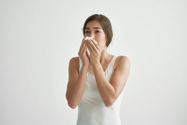 mujer en camiseta blanca se sopla la nariz en una infección de pañuelo en la cabeza frío - Foto, imagen