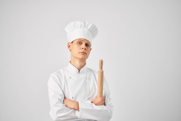 Fröhlicher Koch in der Uniform eines Nudelholzes in den Händen eines Restaurants - Foto, Bild