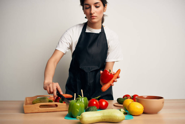 dona de casa na cozinha cortando salada de legumes - Foto, Imagem
