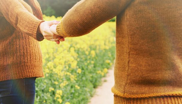couple holding hands in love outdoor into the depth of beautiful - Photo, Image