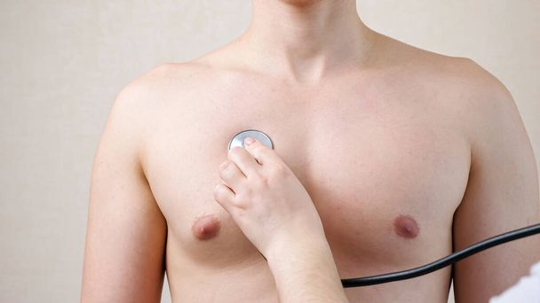 Arzt hört Patientin mit Stethoskop auf nackte Brust - Foto, Bild