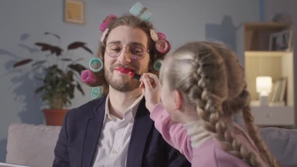 kochający ojciec i córka robi makijaż tacie podczas pracy w izolacji podczas kwarantanny - Materiał filmowy, wideo
