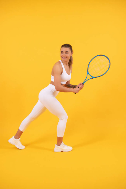uśmiechnięty tenisista biegać z rakietą na żółtym tle, sport - Zdjęcie, obraz