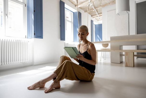 Κομψή γυναίκα με ψηφιακή ταμπλέτα στο μοντέρνο διαμέρισμα - Φωτογραφία, εικόνα
