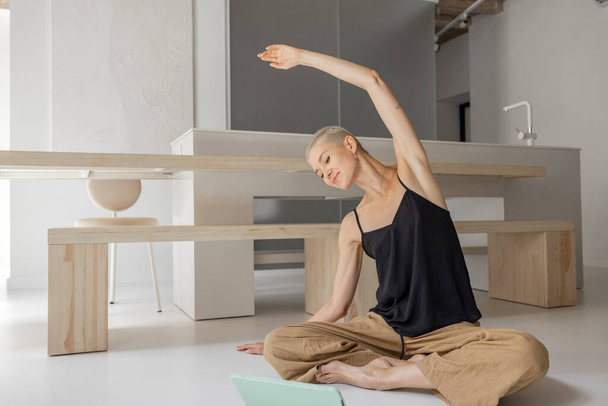 Woman practising yoga at home - Foto, afbeelding