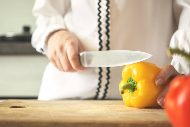 Junge Frau bereitet gelbe Paprika für gesundes Ernährungskonzept zu - Foto, Bild