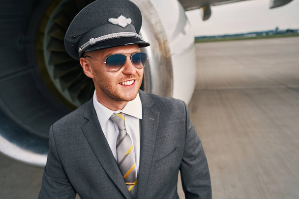 Smiling young Caucasian male pilot on the runway - Фото, зображення