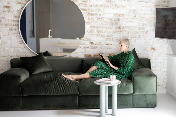Femme élégante avec tablette numérique sur le canapé à la maison - Photo, image