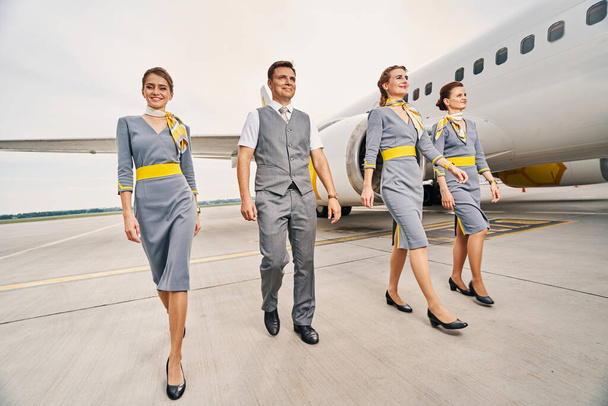 Smiling cabin crew in uniforms walking ahead - Photo, Image