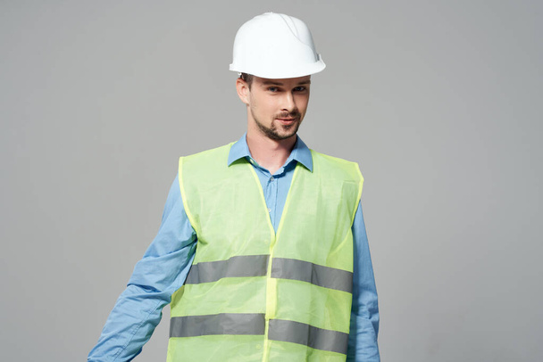 man reflective vest blueprints builder light background - Foto, Imagen